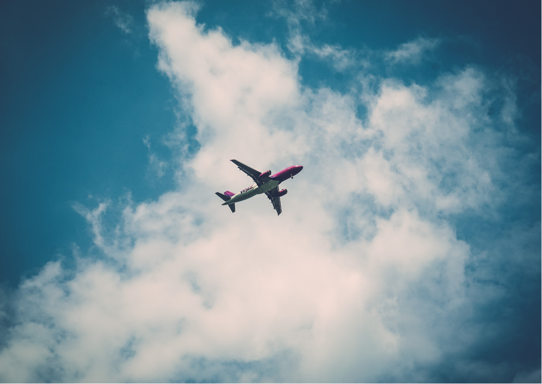 blue sky with white clouds and airplane in distance